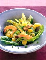 Potato salad with shrimp, avocado, lime, mustard seeds and romaine lettuce on plate