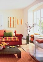 Teilansicht eines Raumes in warmen Farben, Sofa, Bodenvase m. Zweig