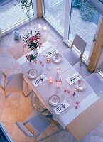 Laid table in conservatory at evening, elevated view