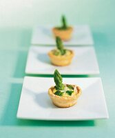 Tarts with asparagus on square plates