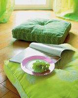 Grapes on plate and magazine on green cushion