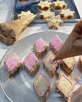 Plätzchen mit rosa Puderzuckerguss verziehren, Spritztütchen