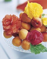 Früchteteller m. bunten Blütenköpfen zwischen Aprikosen