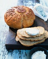 Round potato spelt bread with spices and cream cheese on wooden surface