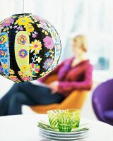 Ball lamp made of floral pattern rice paper hanging over table