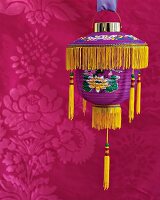 Close-up of lantern in Asian style hanging against floral pattern background