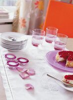 Tisch in weiß und rosa gedeckt, Teller, Teelichthalter, Gläser