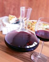 Glaskaraffe " Diva " für Rotwein, daneben ein Glas mit Rotwein
