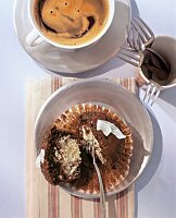 Chocolate and coconut muffin on plate with cup of coffee, overhead view