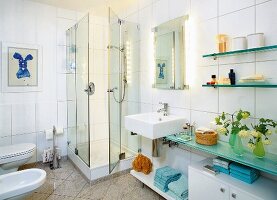 Badezimmer in weiß, Glasduschwand, Waschbecken, Spiegel, Ablagefläche