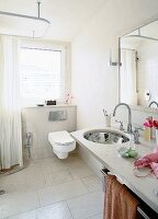 View of bathroom with toilet seat, mirror over sink and marble tiled floor