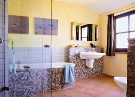 Bathroom with mosaic tiles, glass partition, wash basin and bath tub