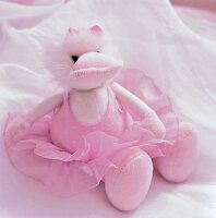 Kuscheltier, Teddy, Teddybär in rosa sitzt auf Bett in Tüllrock