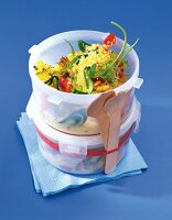 Couscous-Salat in Plastikbehälter mit Holzbesteck