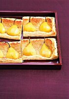 Pear tart with almond cream topped with pears on serving dish