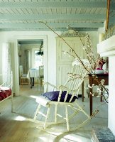 Cherry branches beside old chair with cushion in bedroom