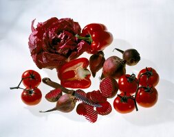 Red cabbage, peppers, tomatoes, beetroot and knife on white background