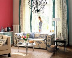 Woman in living room with Toile de Jouy patterned sofa, opening balcony