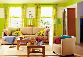 Beige Sofa + Sessel, Beistelltische aus hell. Holz, Wand + Gardinen grün