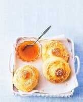 Three brioche of bread, butter and jam on serving dish