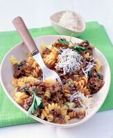 Fusilli with meat sauce and fork in bowl