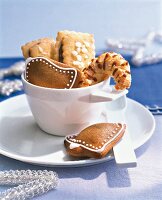Various types of biscuits in white cup with saucer and spoon