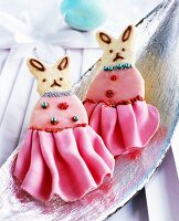 Bunny-shaped biscuits decorated with fondant icing and icing sugar