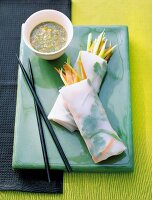 Vegetable wrap served with bowl of chilli sauce