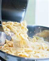 Close-up of noodles being poured from pot to colander