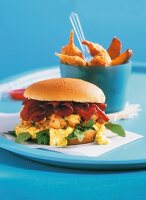 Salmon burger with salmon and chips on blue plate