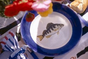 Ceramic plate with blue border and fish decor