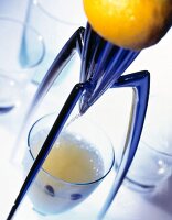 Lemon squeezer and glass of juice