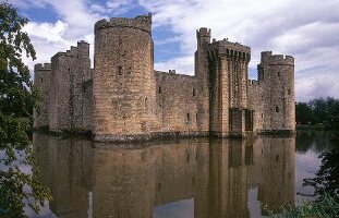 Bodiam Castle with massive stone walls and towers surrounded with water, UK