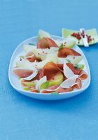 Close-up of carpaccio with ham on serving dish against blue background