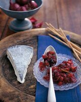 Homemade plum chutney and cheese on wooden board
