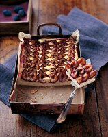 Plum cake with semolina cream and almonds in baking tray