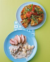Vegetable frittata and pork with mushroom sauce on blue plate, overhead view