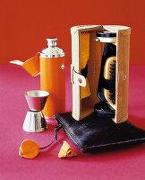Flask, shoe shine box and bag made from cow skin on red background