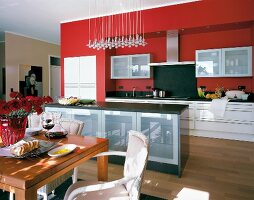 View of red modular kitchen with kitchen block and dining table