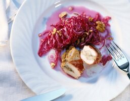 Close-up of crepinette of spring chicken with apple and red cabbage salad on plate