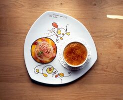 Creme brulee with exotic fruit salad on plate, overhead view