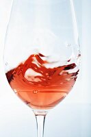 A glass of rose wine being swirled