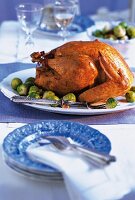 Roast turkey stuffed with dumplings and served with Brussels sprouts