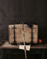 Close-up of old suitcase, walking stick, map, binoculars, time travel on table