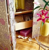 Close-up of wall cabinet with floral wallpaper