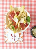 Penne-Chicorée-Salat mit Kirschto- maten + Parmaschinken, Basilikum