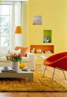 Wohnzimmer in gelb - orange, weißes Sofa, Sessel in Orange