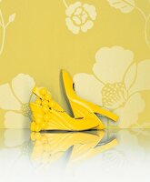 Yellow Sandals and pearl necklace on yellow floral background