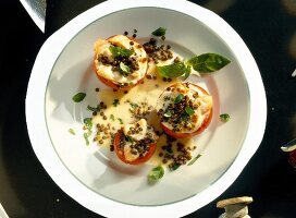 Baked tomatoes with lentil ricotta filling, salmon and parmesan cheese on plate