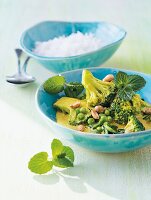 Green vegetable curry and rice in bowls